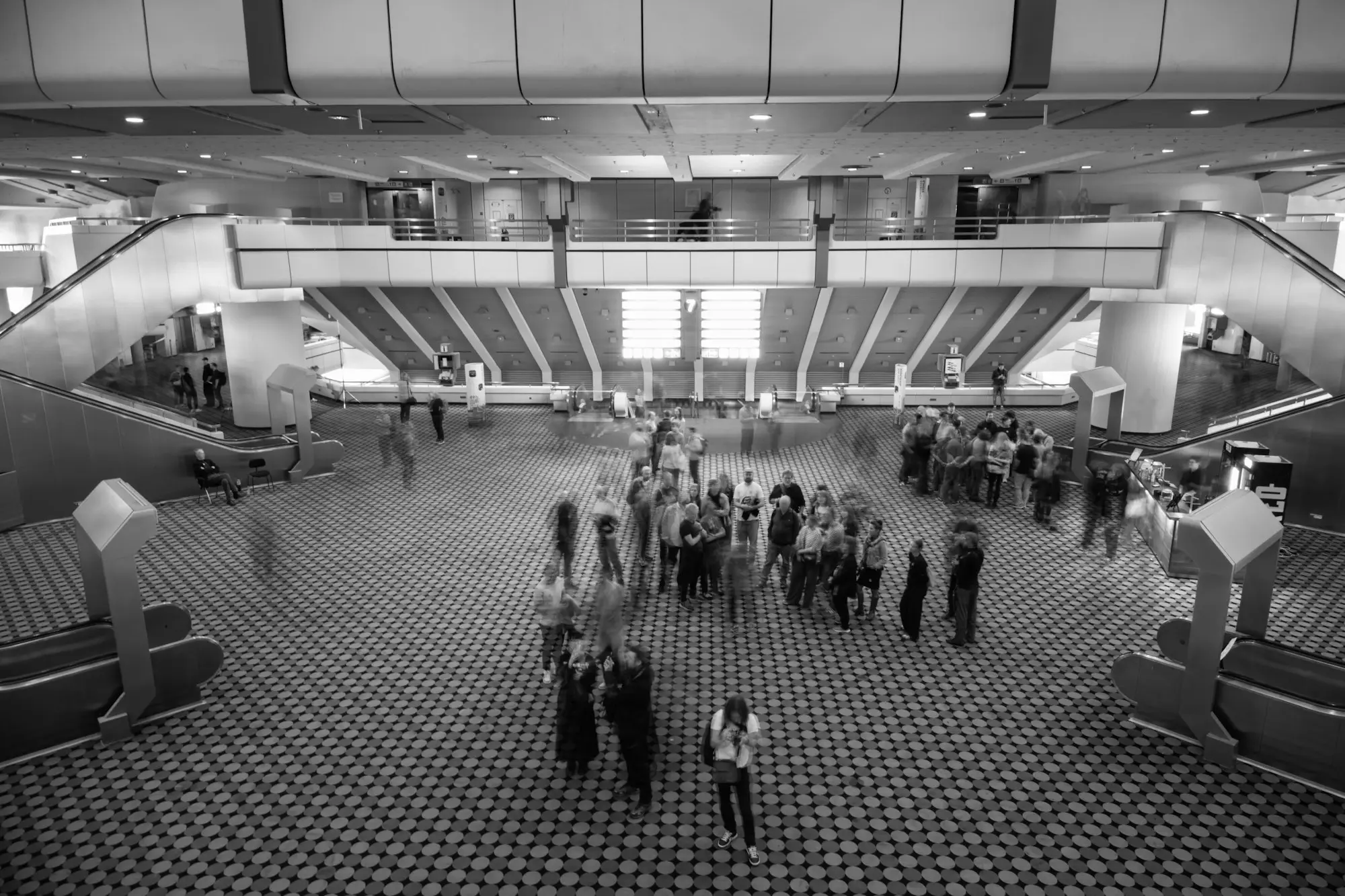 Attendees gathering on the floor of a large event hall